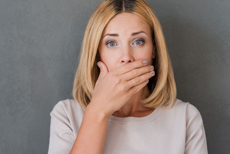 Dental Implant Patient Covering Her Mouth