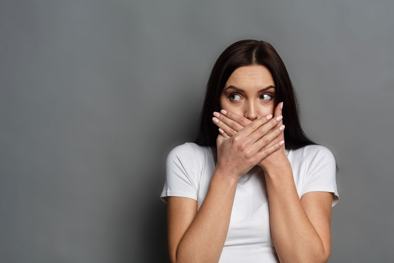 Dental Patient Shyly Covering Her Missing Tooth